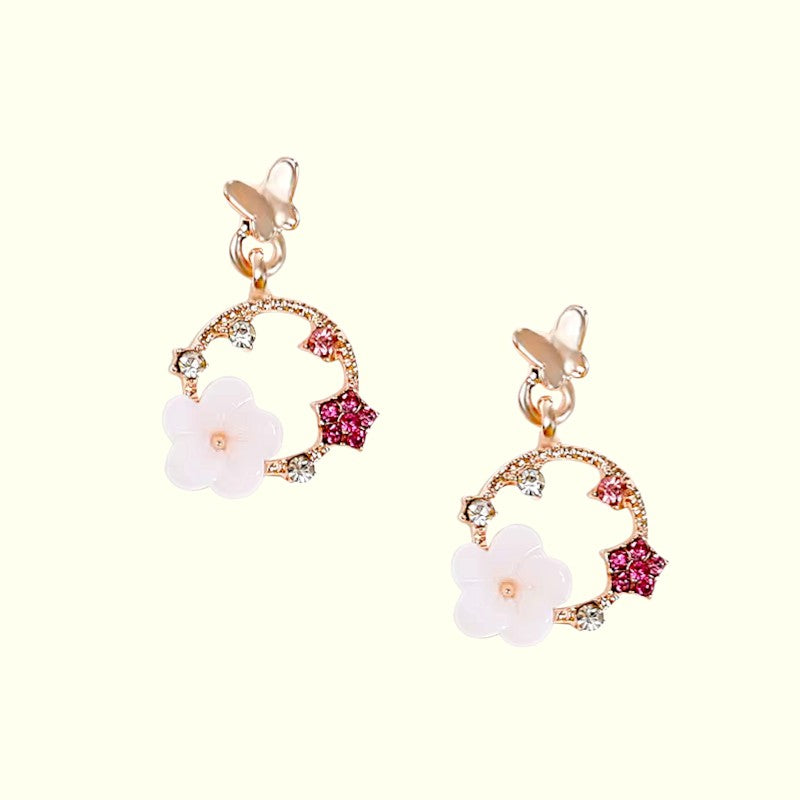 Pair of floral earrings with pink and white flowers on a white background