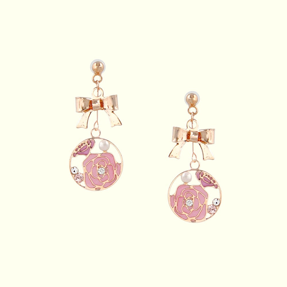 Pair of earrings with pink floral design and bow accents on a white background