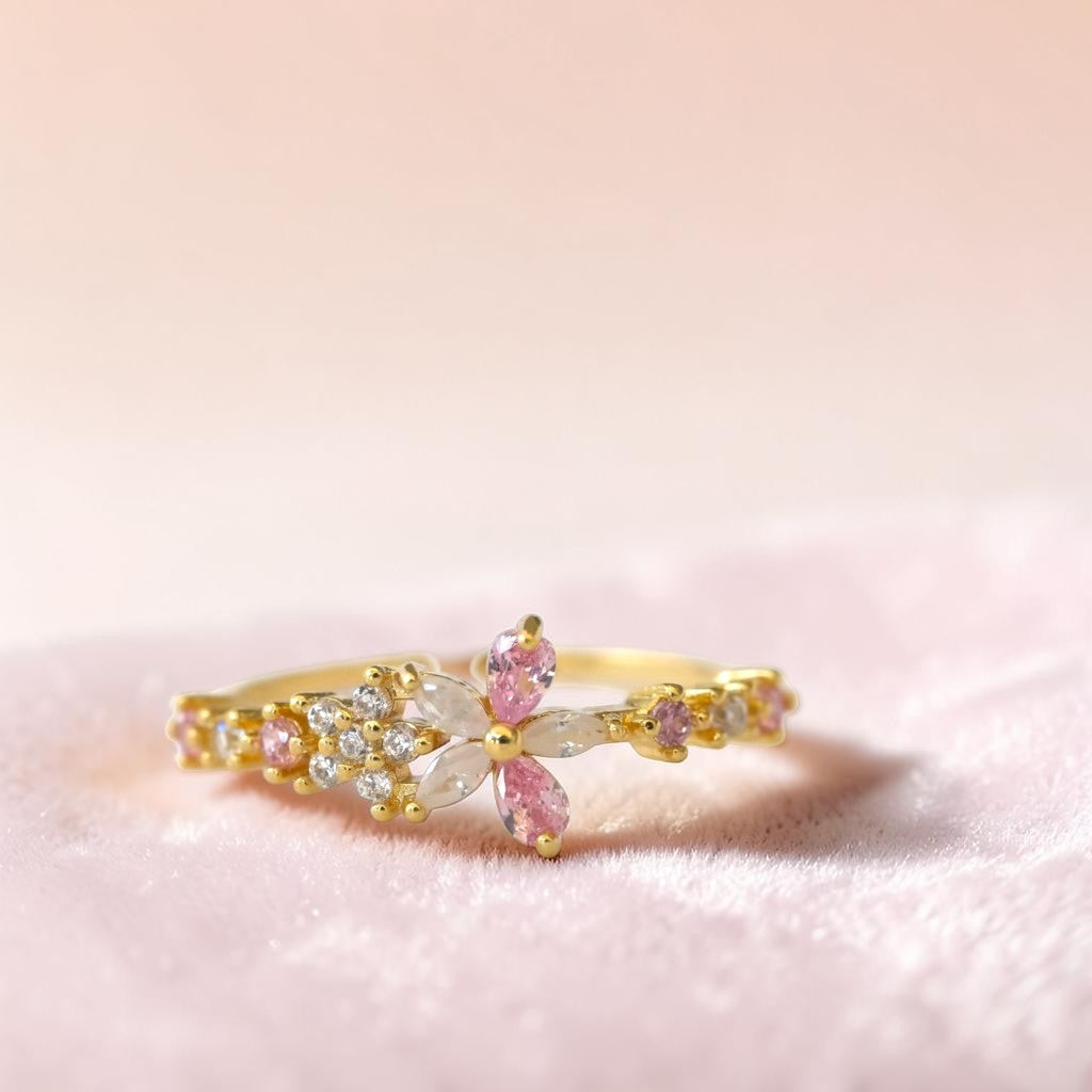 Gold ring with pink gemstones on a pink background