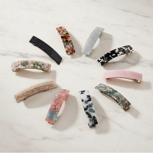 Collection of variously designed hair clips on a light background