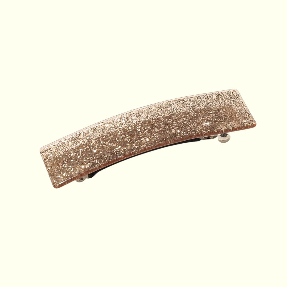 Rose gold glittery hair clip on a white background