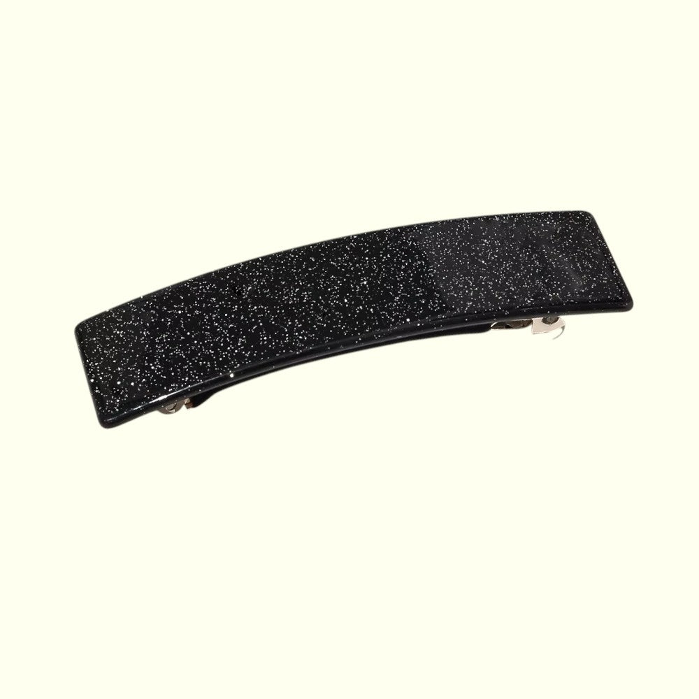Black glittery hair clip on a white background