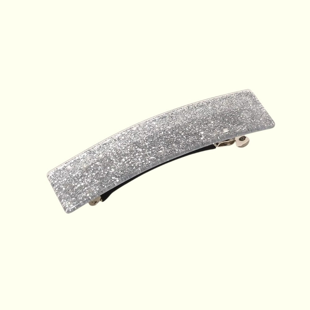 Silver glittery hair clip on a white background