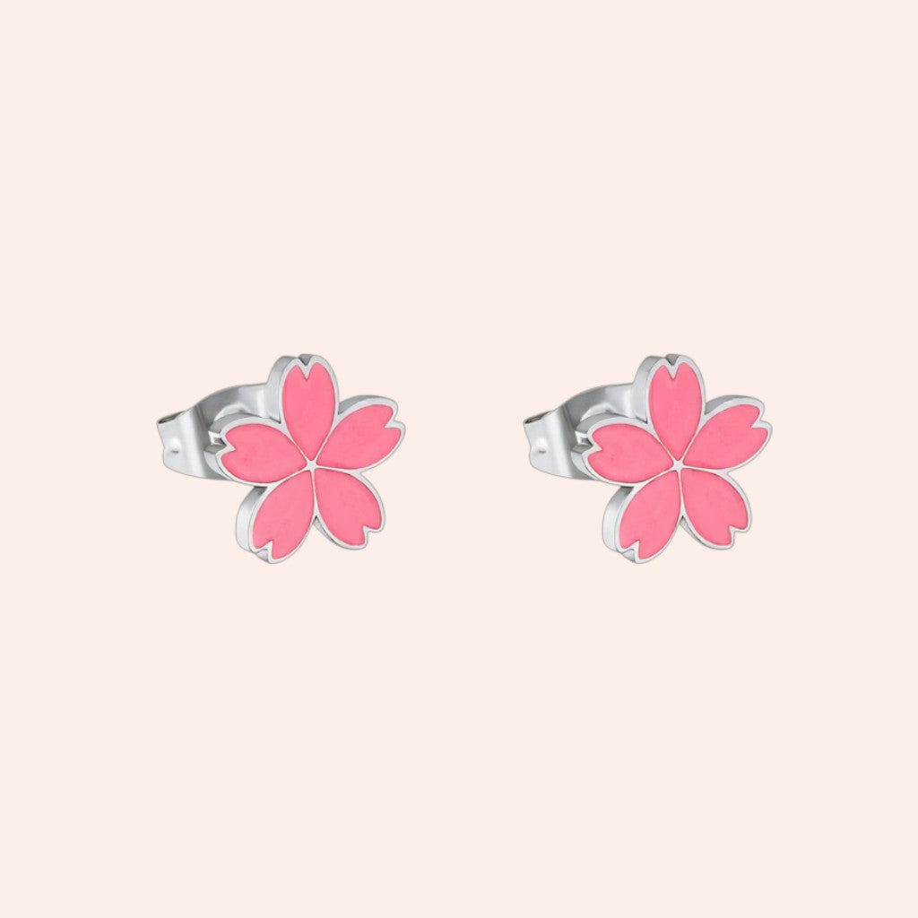 Pair of pink flower-shaped earrings on a light pink background