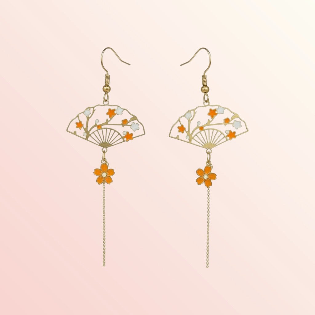 Pair of earrings with fan and flower designs on a light pink background
