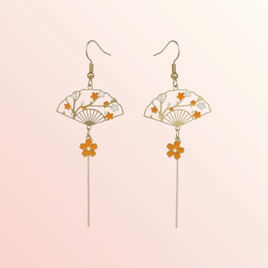 Pair of earrings with fan and flower designs on a light pink background