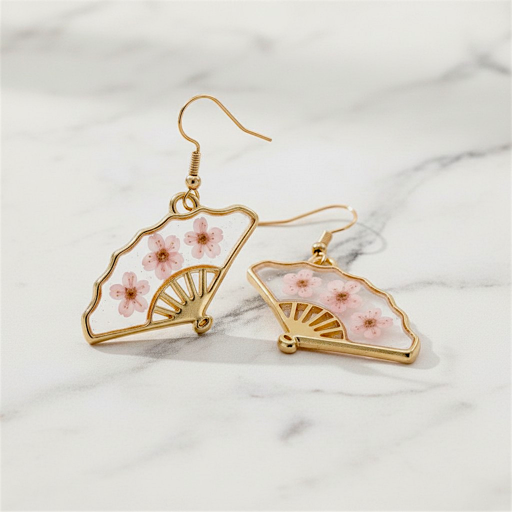 Gold earrings with floral design on a marble surface