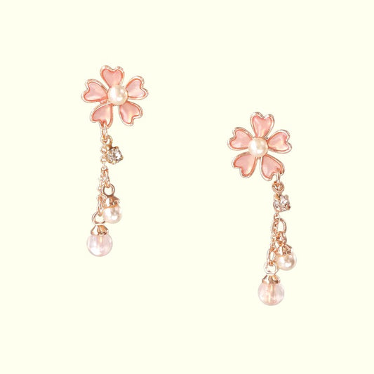 Pair of pink floral earrings with pearl-like beads on a white background