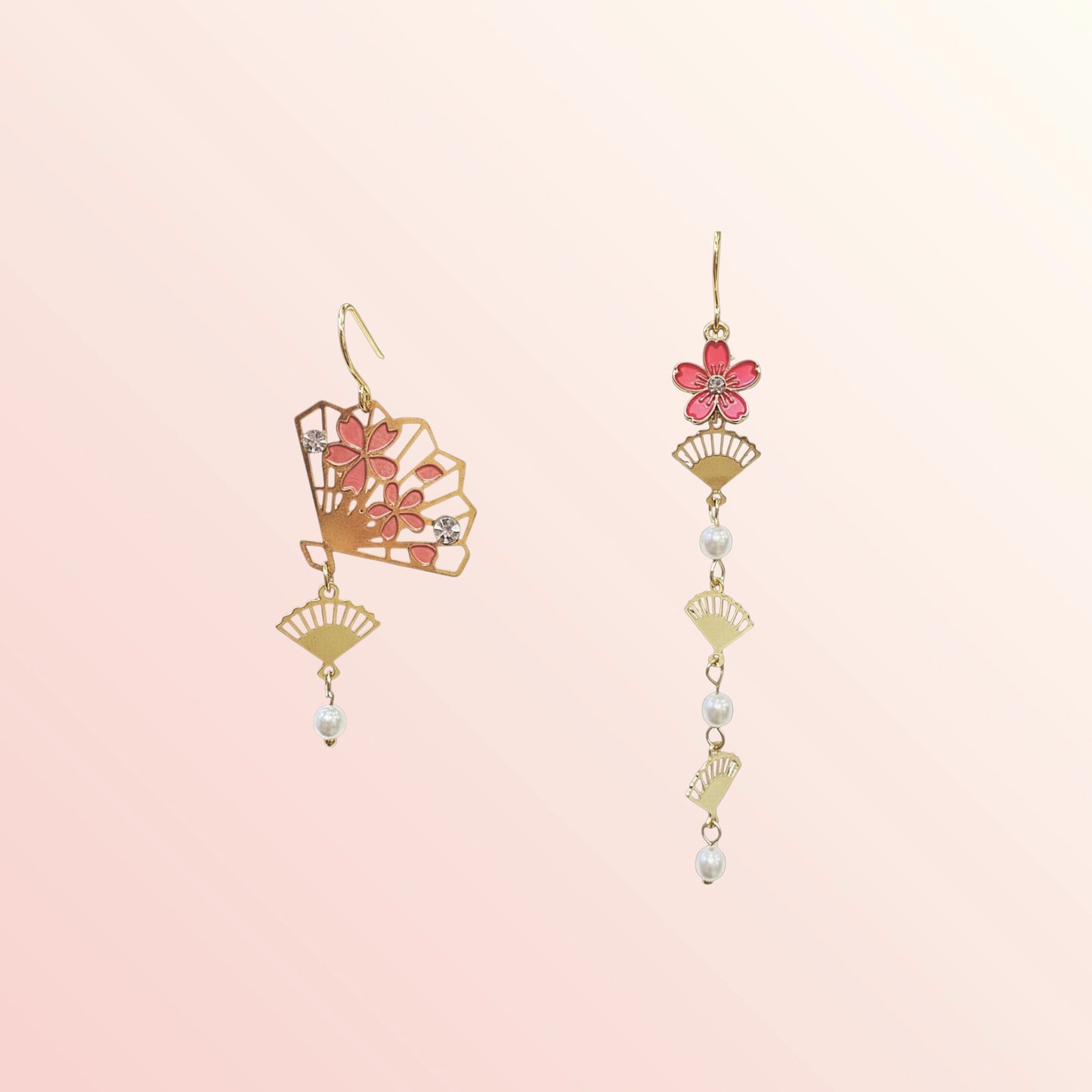 Pair of floral earrings with gold accents on a light pink background