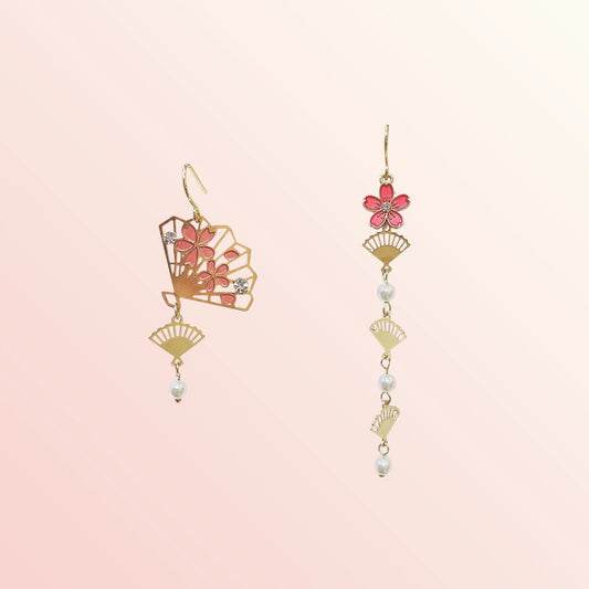 Pair of floral earrings with gold accents on a light pink background
