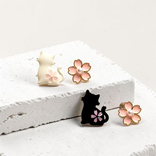 Pair of cat and flower earrings on a white stone surface