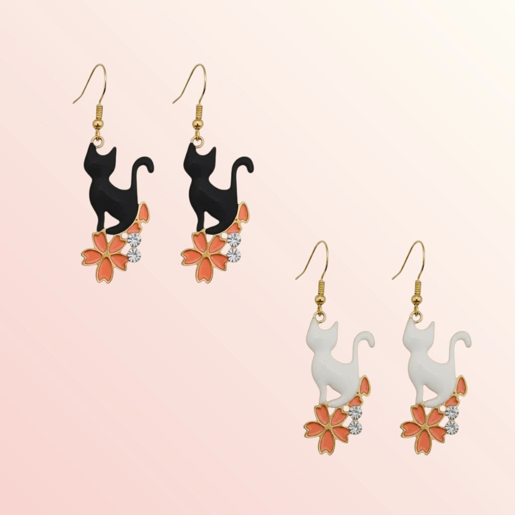 Cat-shaped earrings with floral designs on a pink background