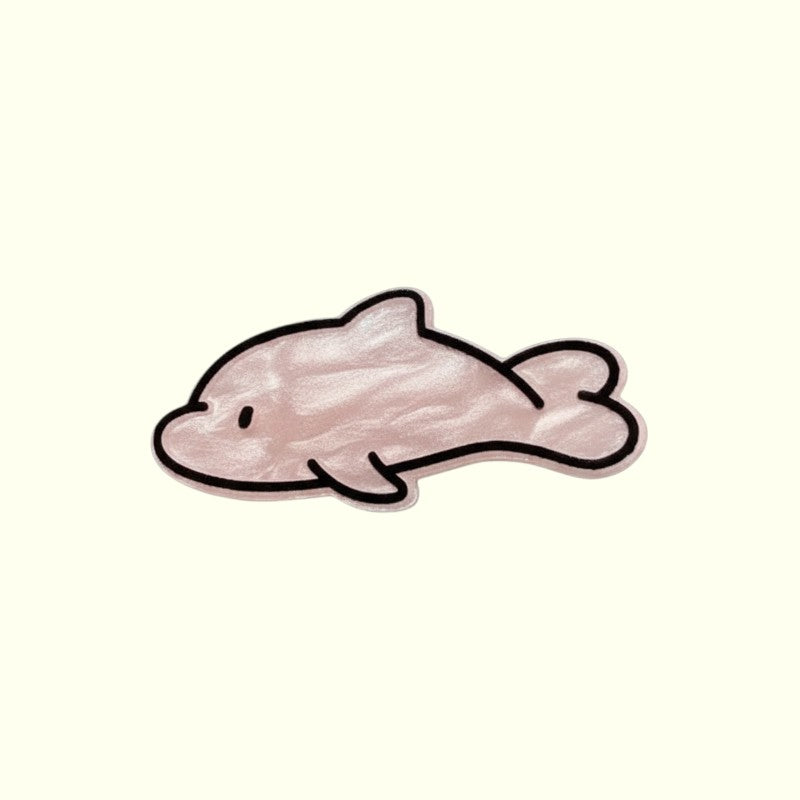 a pink dolphin hair clip on a beige background