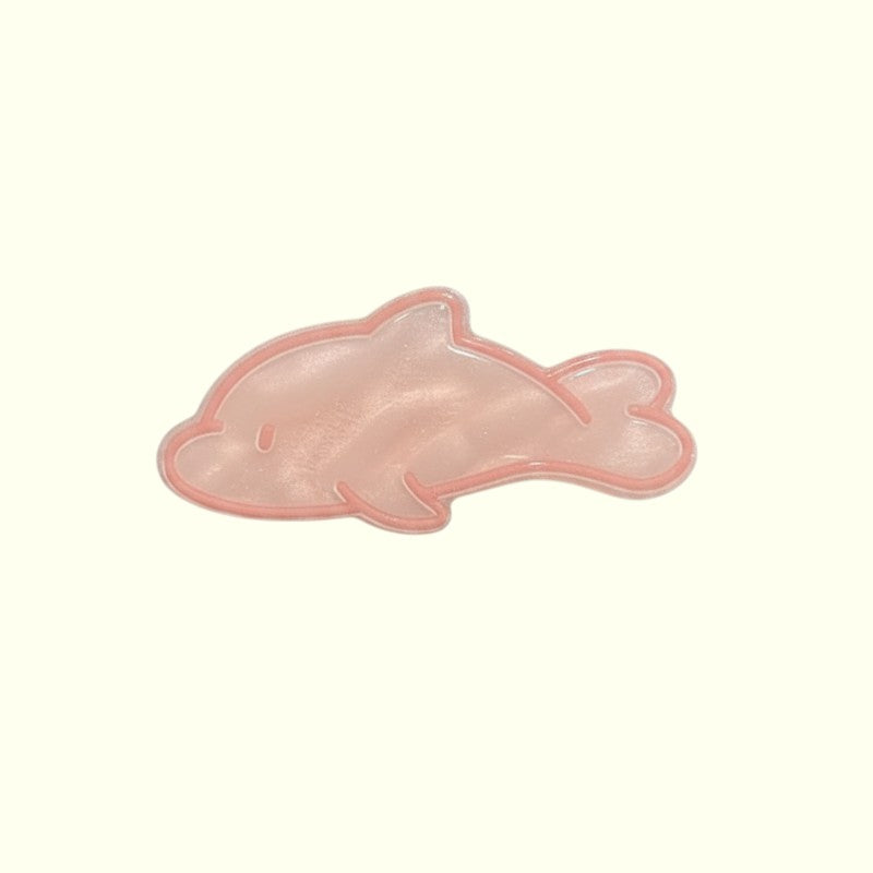 Pink dolphin-shaped hair clip on a white background