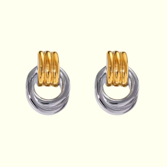 Pair of earrings with gold and silver rings on a white background