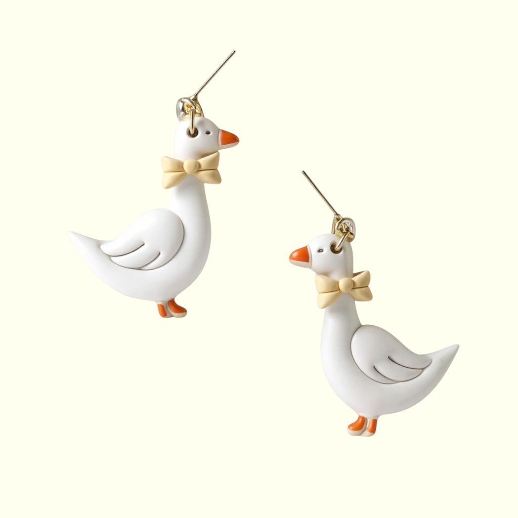 Two white goose-shaped earrings with bow ties on a white background