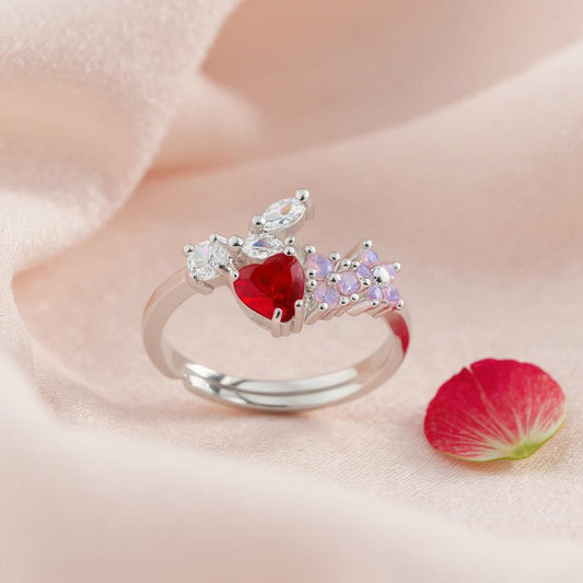 Silver ring with a red gemstone and pink stones on a soft fabric background