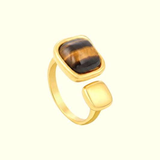 Gold ring with a tiger's eye stone on a white background