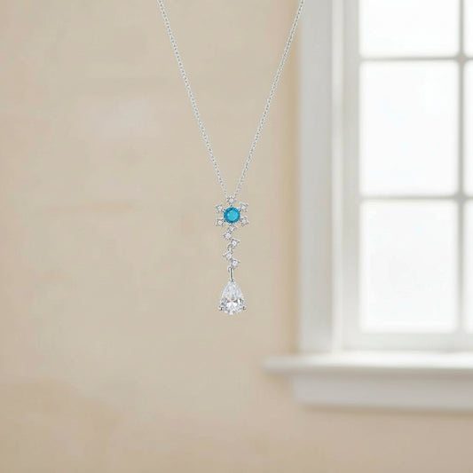 Necklace with a blue gemstone pendant on a beige wall.