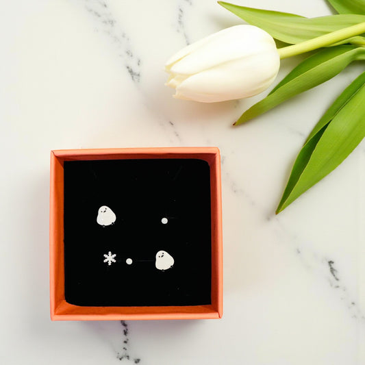 Jewelry box with earrings on a marble surface with a tulip.
