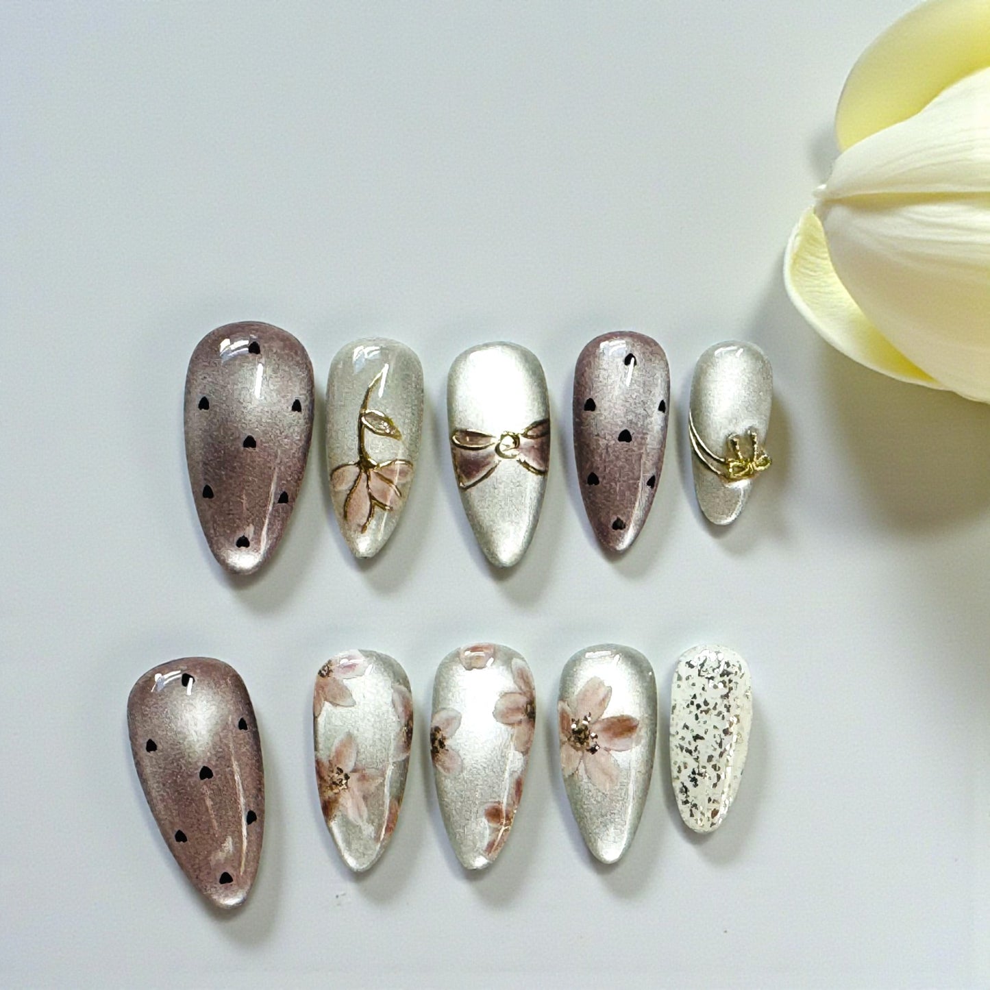 Set of decorative nail art on a white background with a yellow flower.