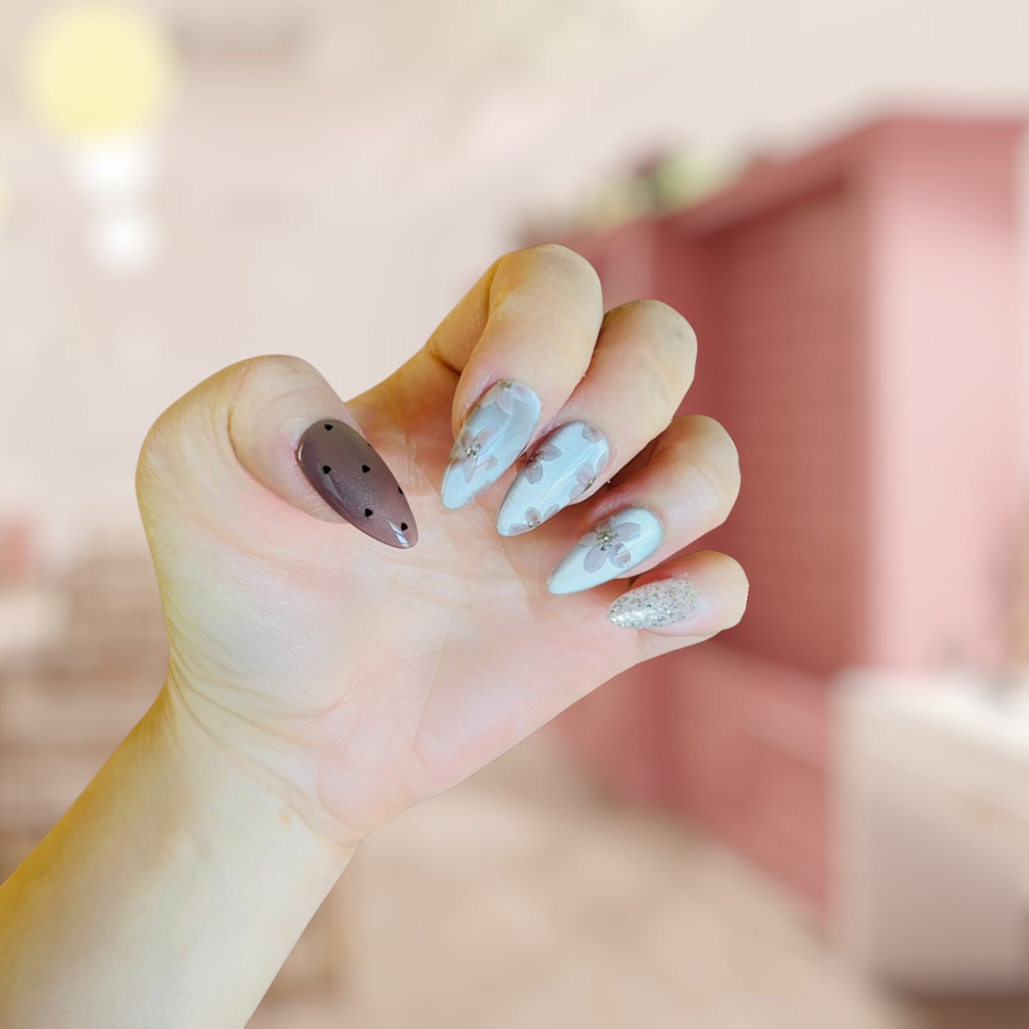 Close-up of a hand with decorative nails against a blurred background
