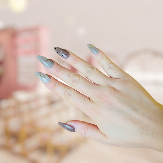 Close-up of a hand with light blue nail polish on a blurred background