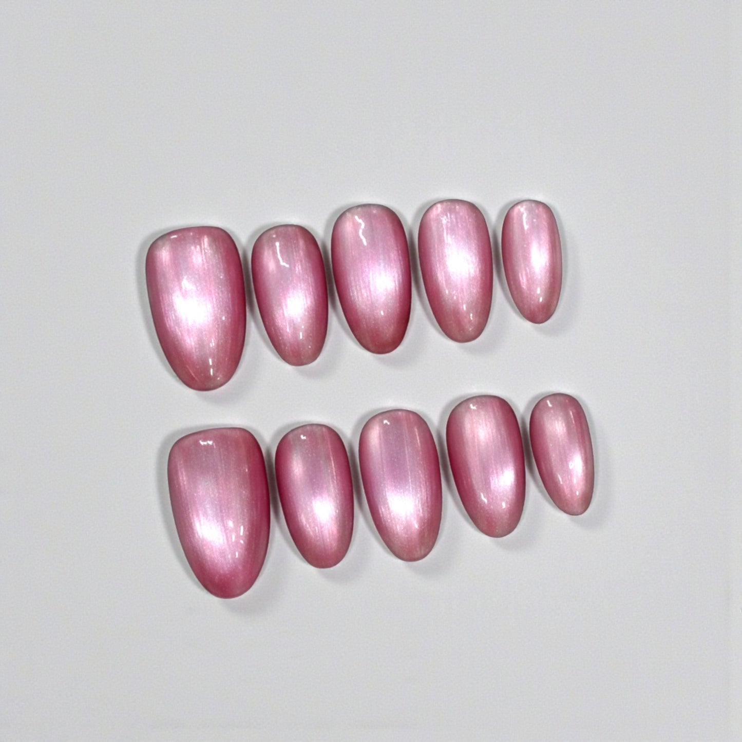 Pink nail polish samples on a light gray background