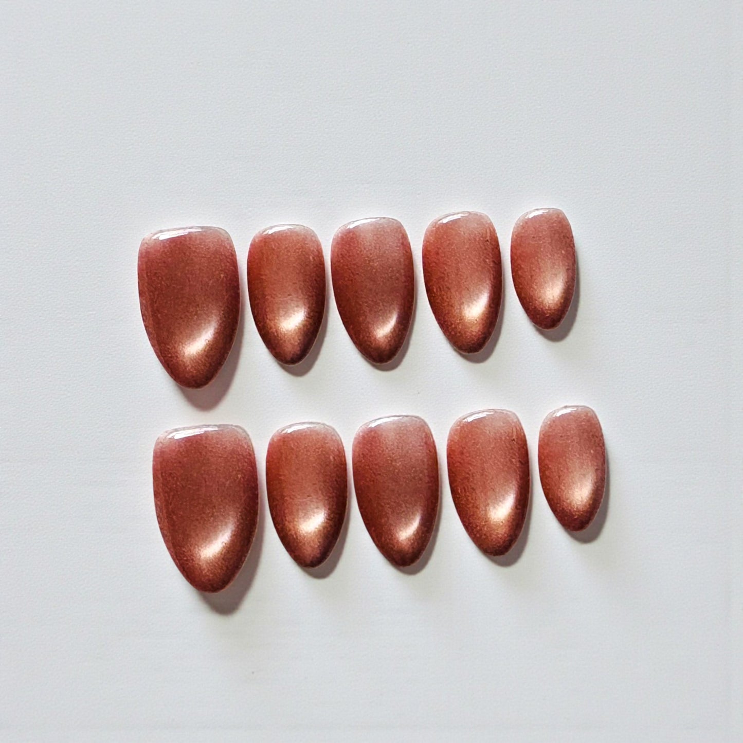 Set of red nail polish swatches on a light gray background