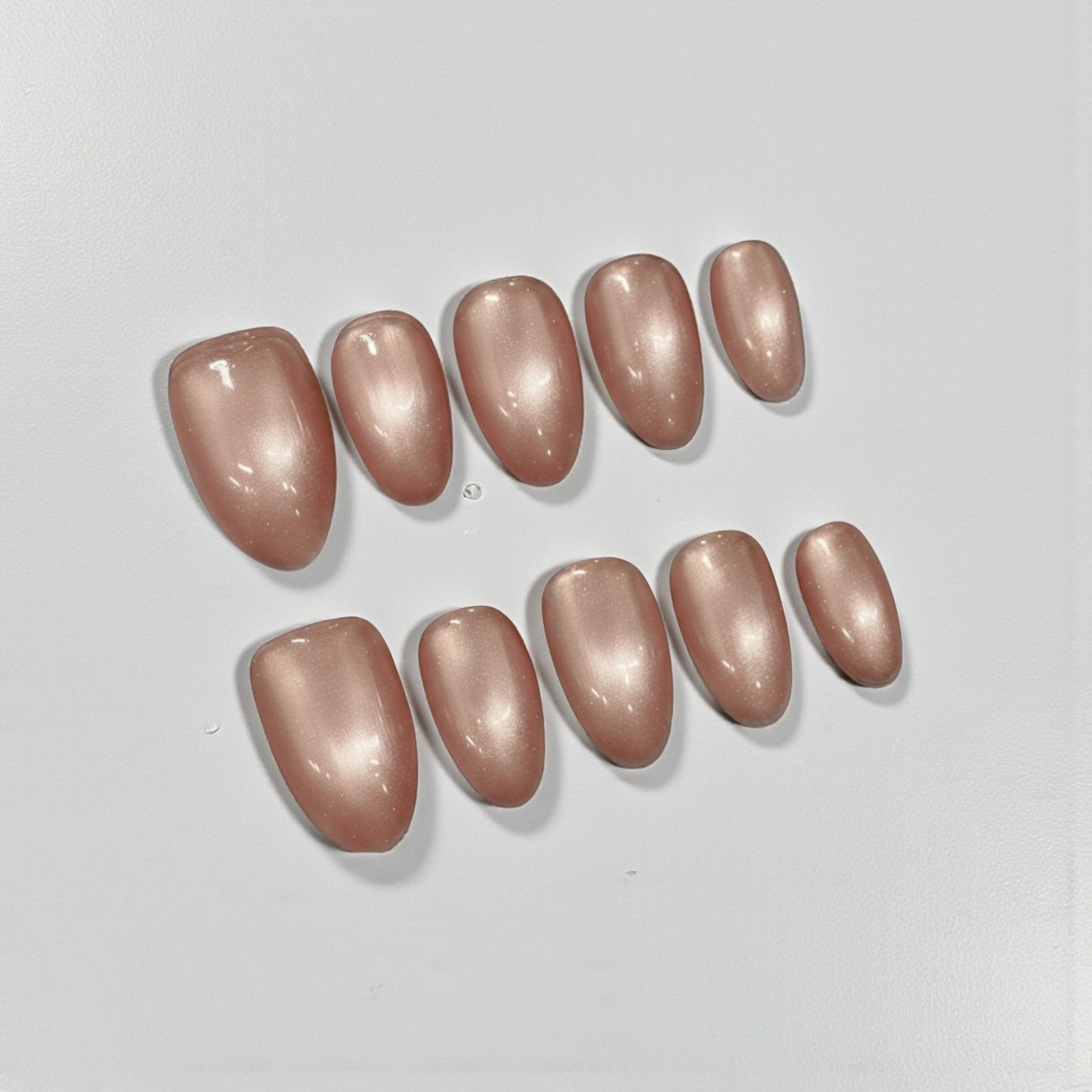 Set of brown nail polish samples on a light gray background