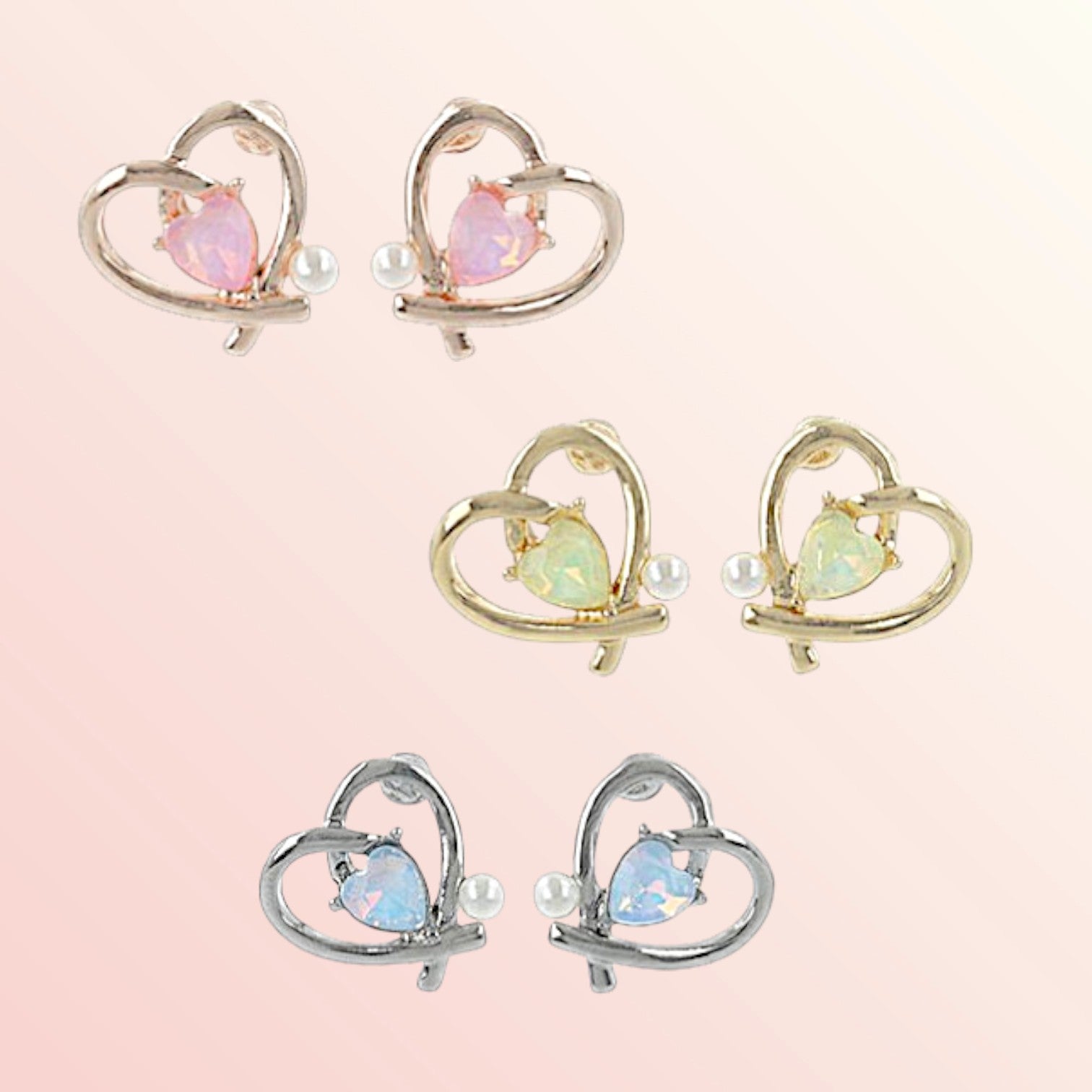 Set of heart-shaped earrings with gemstones on a light pink background