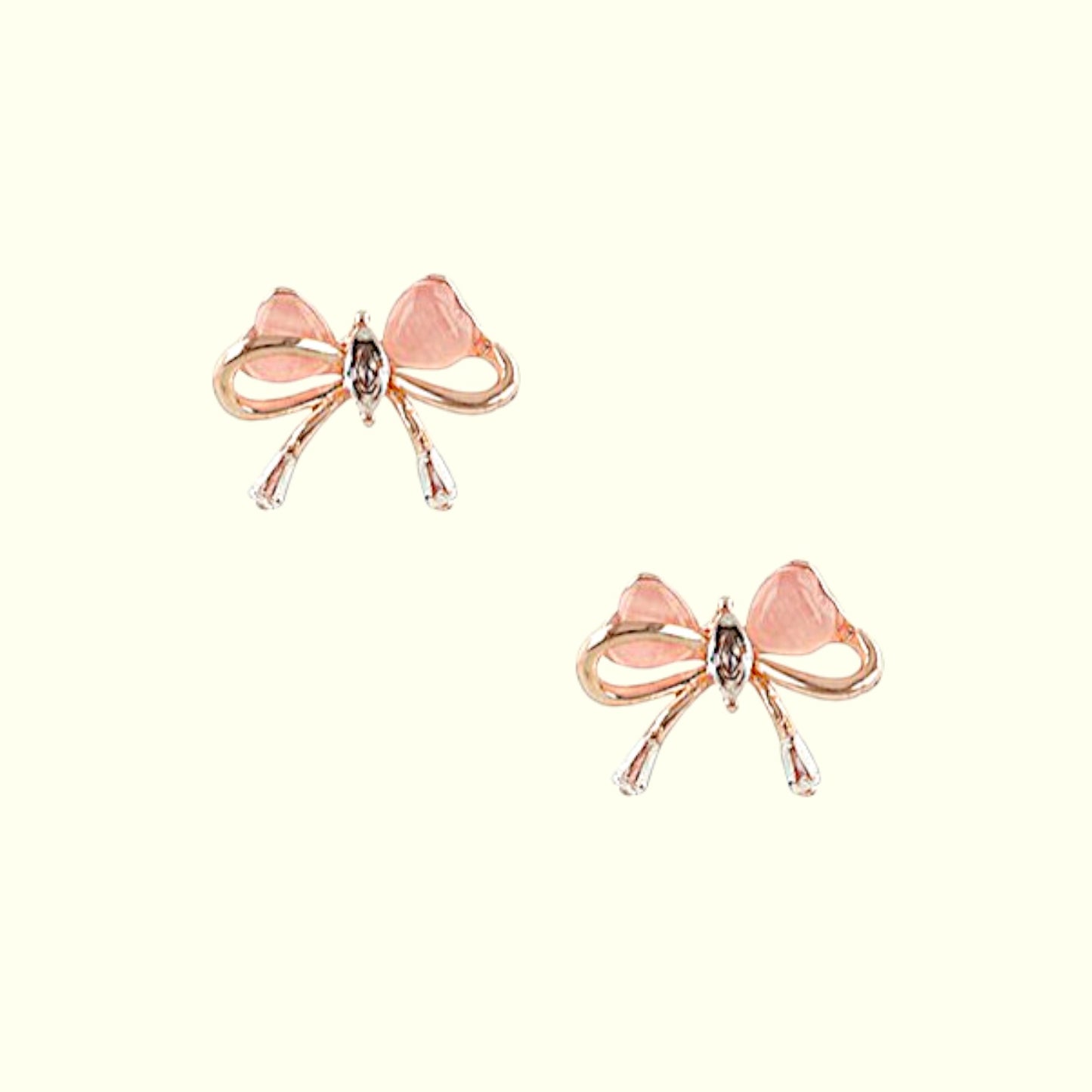 Pair of bow-shaped earrings with pink centers on a white background