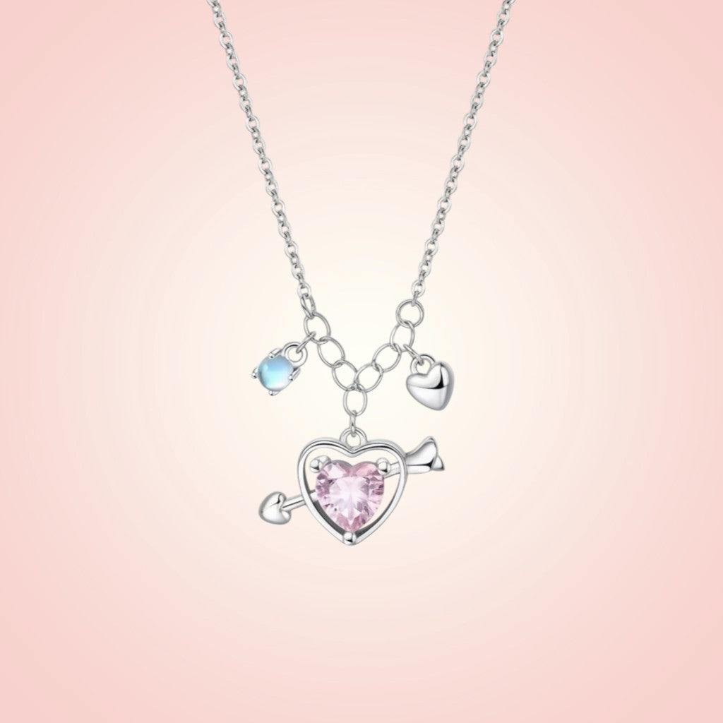 Necklace with heart-shaped pendant and pink gem on a pink gradient background
