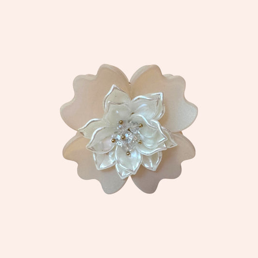 Decorative flower with pearl-like stones on a light pink background