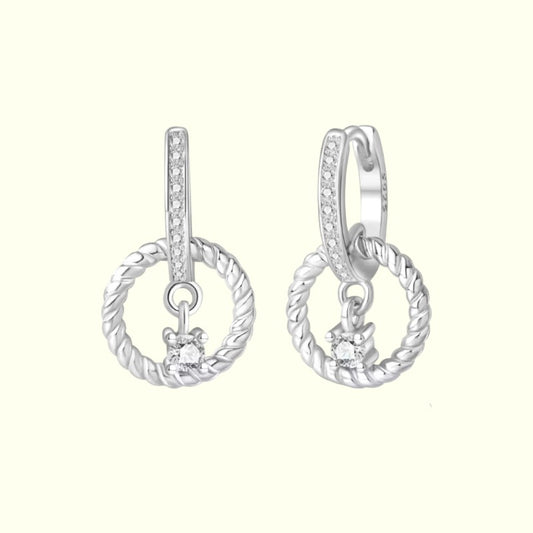Pair of silver hoop earrings with small diamond-like stones on a white background