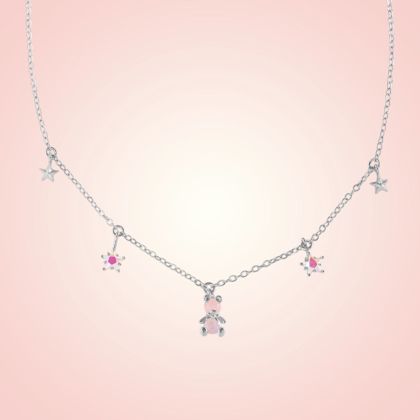 Necklace with star and teddy bear pendants on a pink background