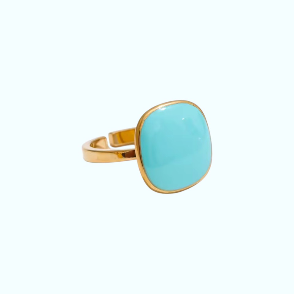 Turquoise ring with gold band on a white background