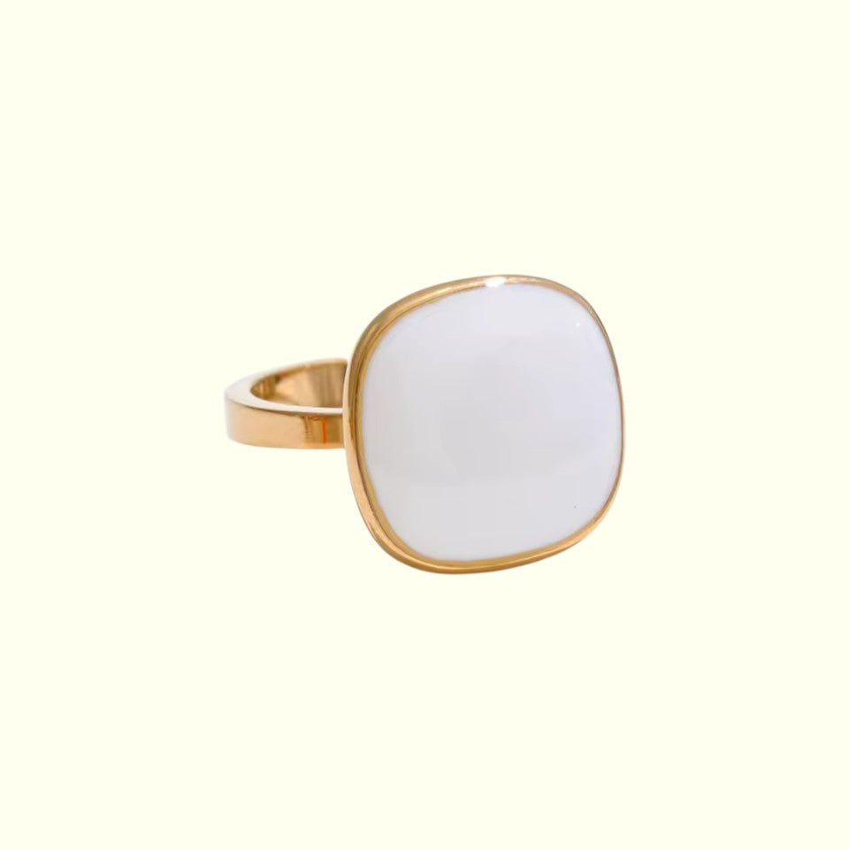 Gold ring with a white stone on a white background