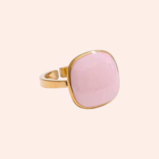 Ring with pink stone and gold band on a white background