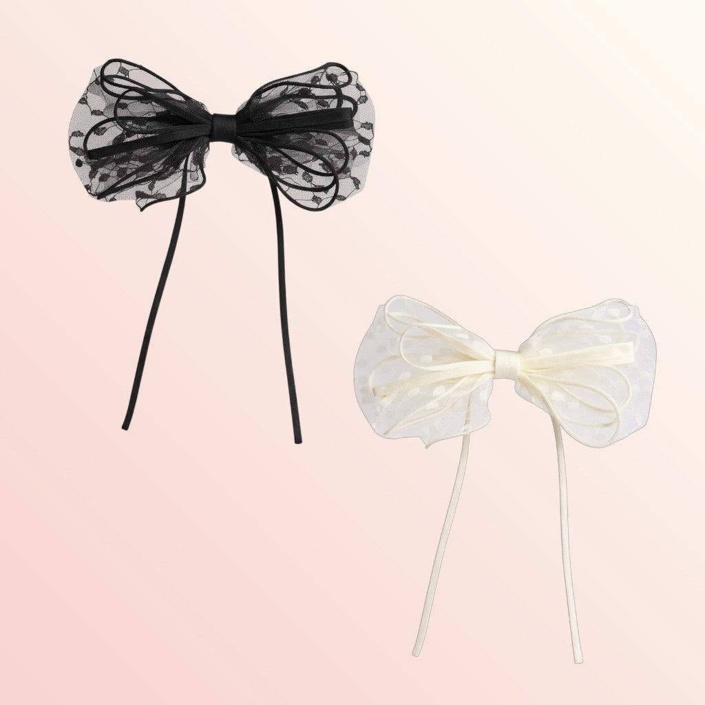 Black and white sheer bow hair accessories on a light pink background