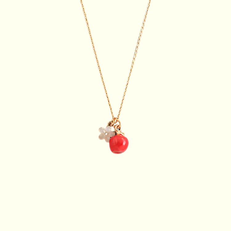 Necklace with a red pendant and gold chain on a white background