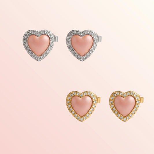 Heart-shaped earrings with pink centers and gold and rose gold accents on a light pink background