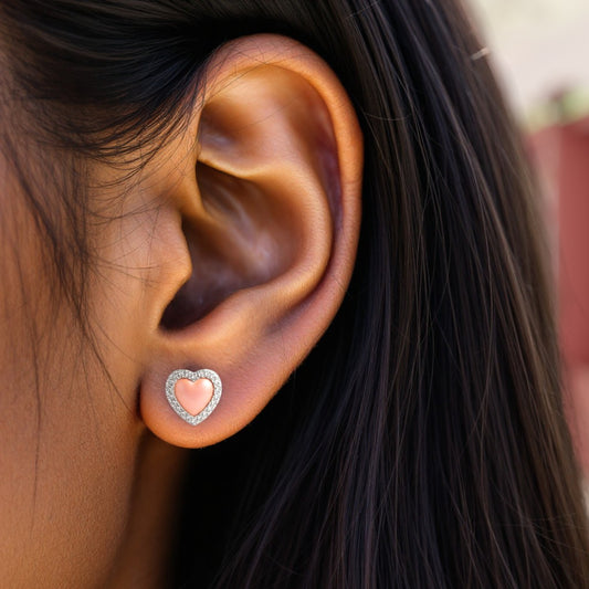 Heart-shaped earring worn by a person with dark hair.