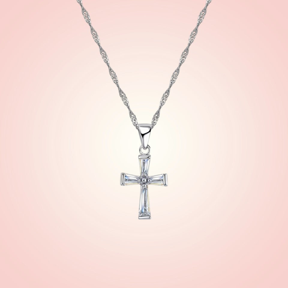 Silver cross pendant necklace on a pink gradient background