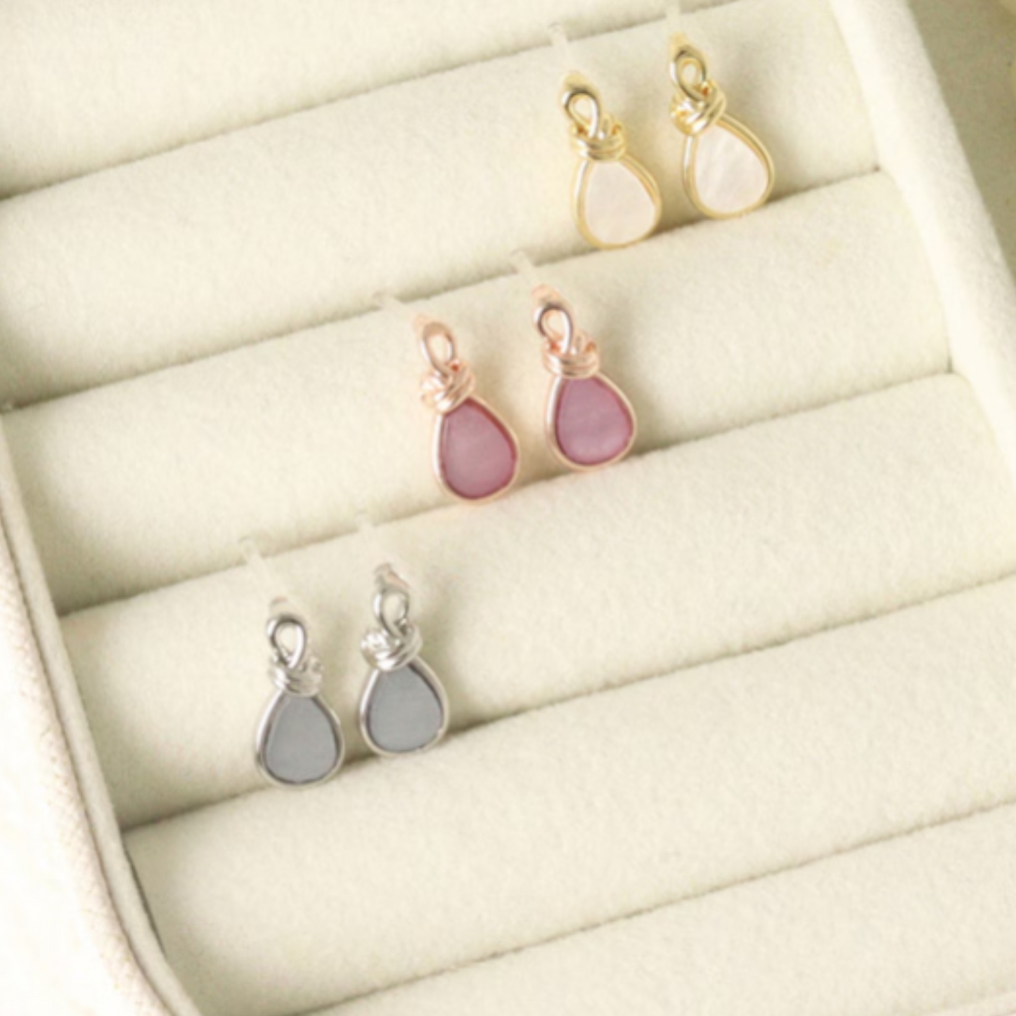 Set of teardrop-shaped earrings on a jewelry tray