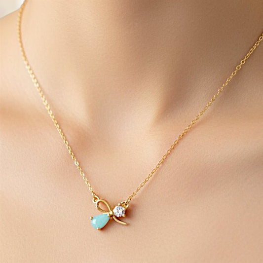 Gold necklace with a turquoise pendant on a person's neck