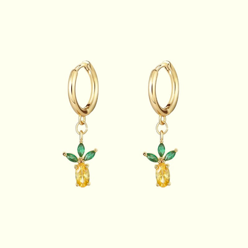 Gold hoop earrings with yellow gemstones and green leaves on a white background