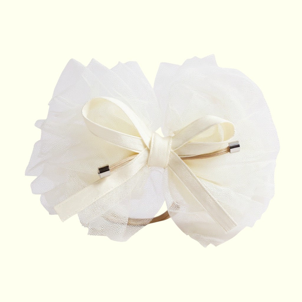 Large white bow with decorative elements on a light beige background