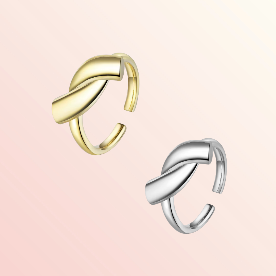 Gold and silver ear cuffs on a light pink background