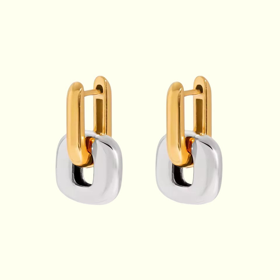 Pair of gold and silver hoop earrings on a white background